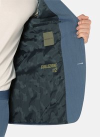 Blauer Blazer mit einer strukturierten Außenseite und einem glatten dunkelgrünen Futter. Verfügt über Markenzeichen und einen "COLLEZIONE #2"-Aufdruck auf dem Futter.