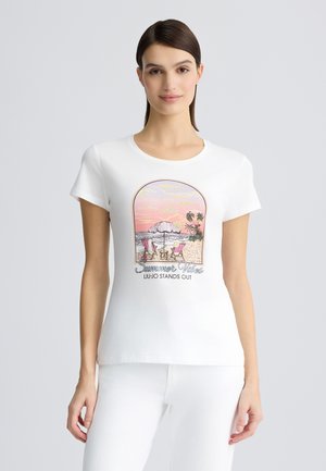 T-shirt in cotone bianco con scollatura rotonda, caratterizzato da una stampa grafica di una scena di spiaggia, "Estremi di Estate", e palme in colori pastello.
