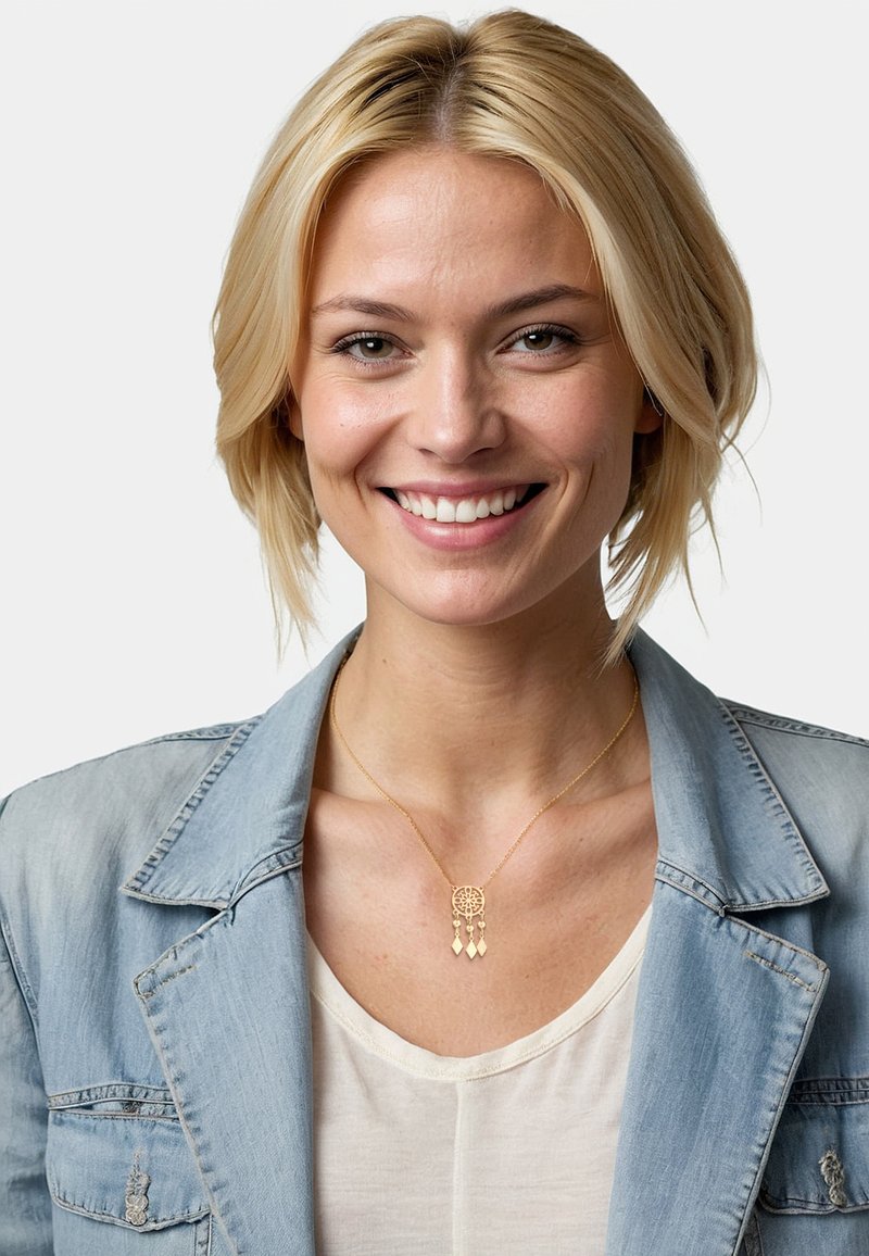 Guldhalsband med cirkulär medaljong och tre hängande diamantformade detaljer, bärs över en ljus skjorta och denimjacka.