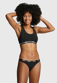 Schwarzes Sport-BH- und Bikini-Set aus weichem Stoff, mit rundem Ausschnitt und elastischem Bund mit weißem "PUMA"-Logo.