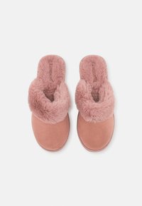 Rosa fluffiga tofflor med en mjuk konstpälsovandel och en slät, mockaliknande sula. Öppen tå-design med en plyschkrage för komfort.