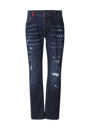 Jeans in denim blu scuro con taglio dritto, caratterizzati da toppe consumate, schizzi di vernice e una piccola etichetta rossa sulla cintura.
