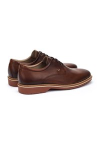 Chaussures habillées en cuir marron avec une texture lisse, un design à lacets, un bout arrondi et des coutures contrastantes le long du bord de la semelle.