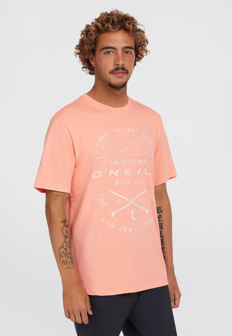 Kortærmet, koral T-shirt lavet af blødt stof med et trykt grafik i hvid, herunder en bjørn og krydsede surfbrædder.