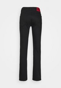 Pantalones de stretch negros con un diseño de pierna recta. Presenta una etiqueta roja en la cinturilla y dos bolsillos traseros, confeccionados en una tela suave.