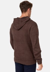 Haut à capuche en tricot marron avec une surface texturée, doté d'une capuche et de poignets côtelés. Le design présente une coupe ample et une couleur unie.