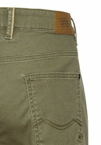 Olijfgroene broek gemaakt van stevig materiaal, met een leren label met "Camel Active" en subtiele stiksels op de achterzakken.