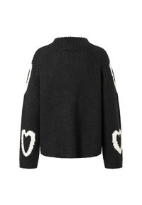 Schwarzer Strickpullover mit hohem Kragen, der große weiße Herzmuster auf beiden Ärmeln und eine verkürzte Silhouette aufweist.