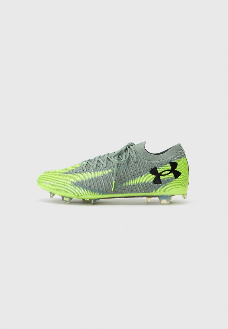 Futbolo batai pilkos ir neon žalias spalvų, su tekstūruota viršutine dalimi, juodu logotipu ir formuotais dėklais, skirtais sukibimui ant žolės paviršių.