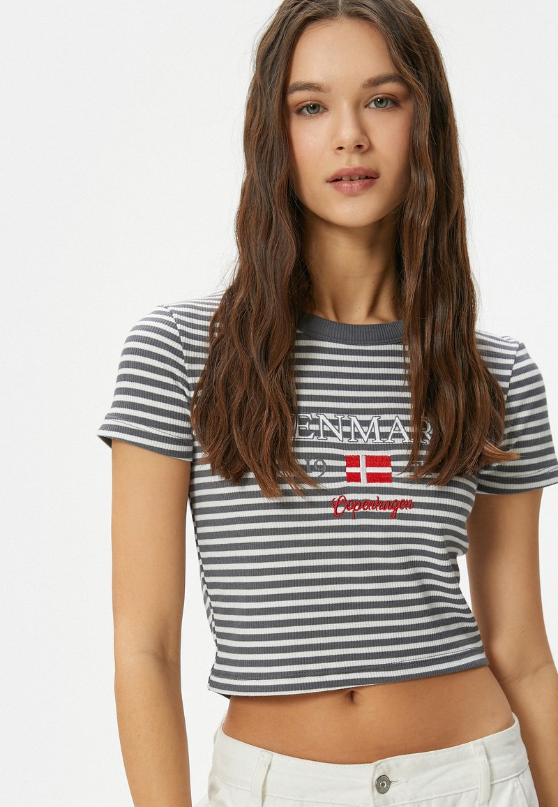 Grå och vit randig kortärmad t-shirt med korta ärmar, prydd med röd broderad text "DANMARK" och en flagggraphic.