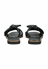 Schwarze Leder-Sandalen mit Riemen, flacher Sohle und einer glatten matten Oberfläche. Sie verfügen über eine offene Zehenpartie und seitliche Aussparungen.