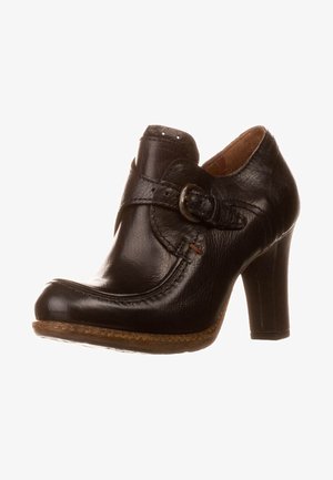 Scarpa nera in pelle con tacco, caratterizzata da una punta arrotondata, un accentuato fibbia e dettagli testurizzati sulla parte superiore. Tacco alto e robusto con una suola simile al sughero.