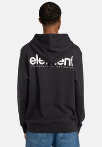 Schwarzer Kapuzenpullover mit einer Kängurutasche vorne, Kordelzugkapuze und weißem "Element"-Logo, das auf dem Rücken gedruckt ist. Der Stoff ist weich und strukturiert.