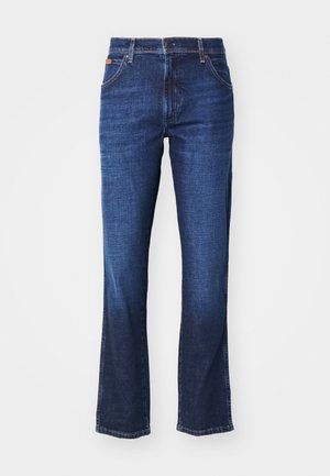 Mørkeblå denimbukser med rett ben-design, fem lommer, og knapp- og glidelås lukking. Subtil fading over stoffet.