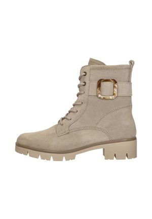 Beige suede ankle boot with lace-up front, chunky sole, low heel, and decorative tortoiseshell buckle strap on the side.