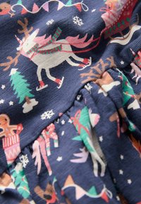 Blauwe stof met een feestelijk patroon van rendieren, bomen, sneeuwvlokken en ontbijtfiguren. Voegt textuur toe met geplooide details.