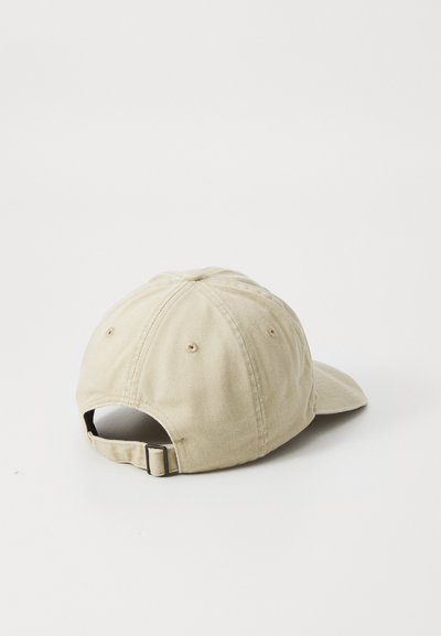 Casquette de baseball en coton beige avec une visière courbée, une sangle ajustable à l'arrière et des détails de couture ton sur ton.