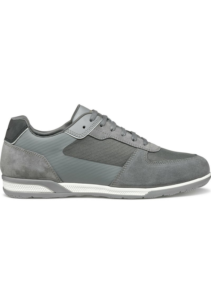 Scarpa sportiva grigia che presenta una combinazione di materiali in suede e rete, un design testurizzato, chiusura con lacci e una suola intermedia bianca.