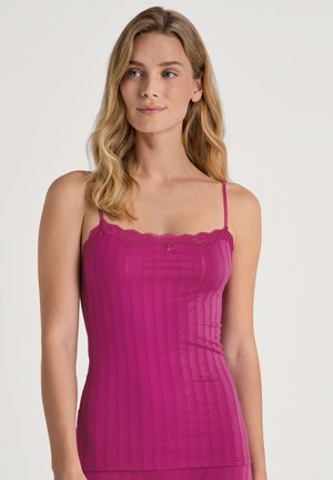 Fuchsia geribde cami-top met dunne bandjes, kantafwerking langs de halslijn en een klein strikdetail in het midden. Zachte, gestructureerde stof.