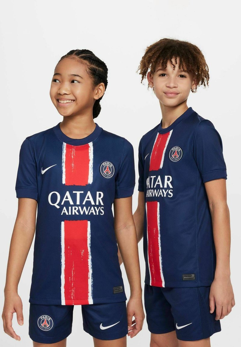 Kit de football pour les jeunes Paris Saint-Germain de Nike comprenant un maillot bleu avec une bande verticale rouge et le texte "QATAR AIRWAYS" en blanc, associé à un short bleu.