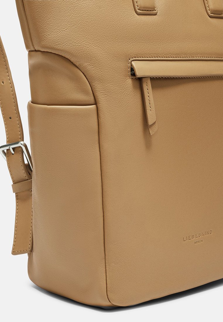 Braune Ledertasche mit strukturiertem Design, glatter Oberfläche, verstellbarem Tragegurt und einem Reißverschlussfach. Markenlogo auf der Vorderseite eingeprägt.