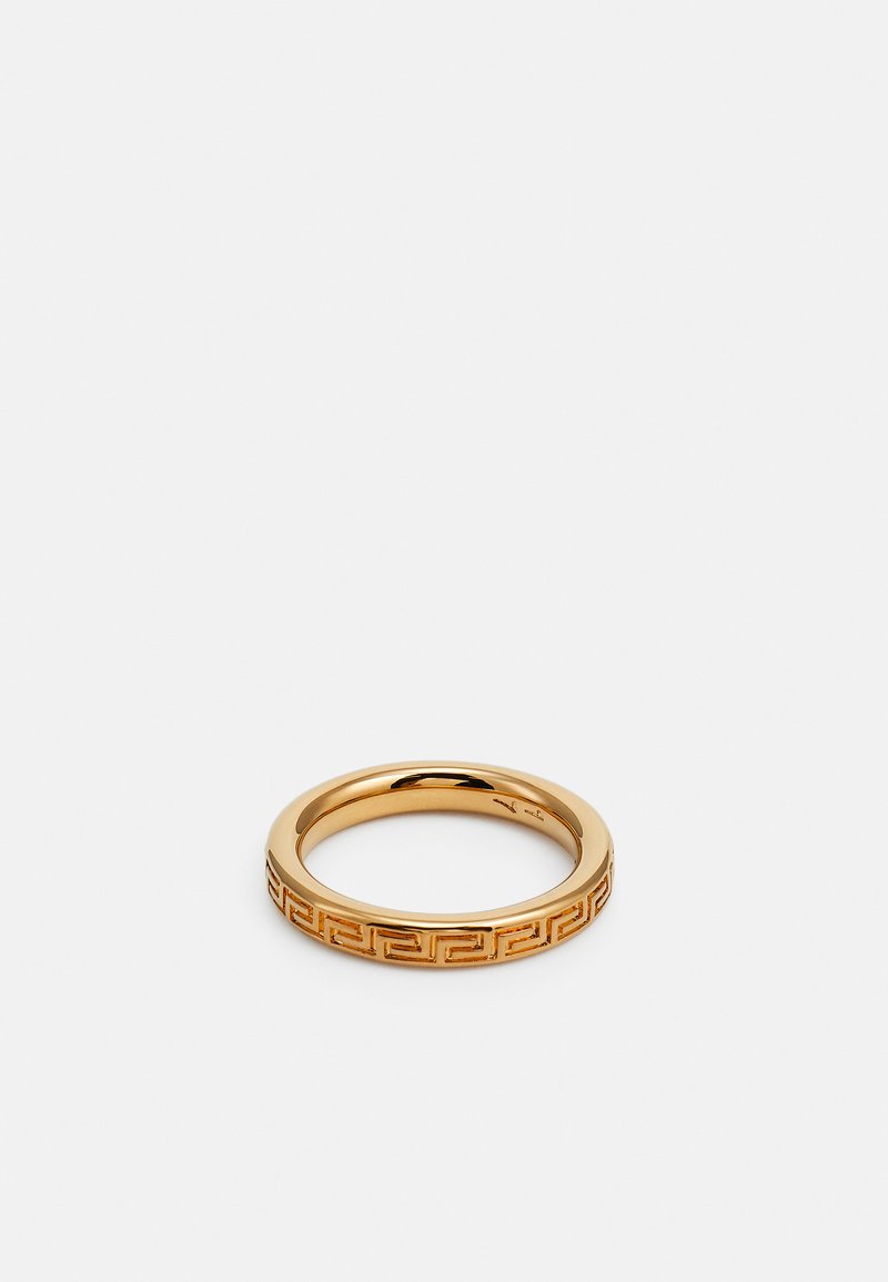 Anello d'oro con una finitura liscia e lucida e un intricato motivo a chiave greca sulla fascia. Forma circolare, texture di metallo lucido.