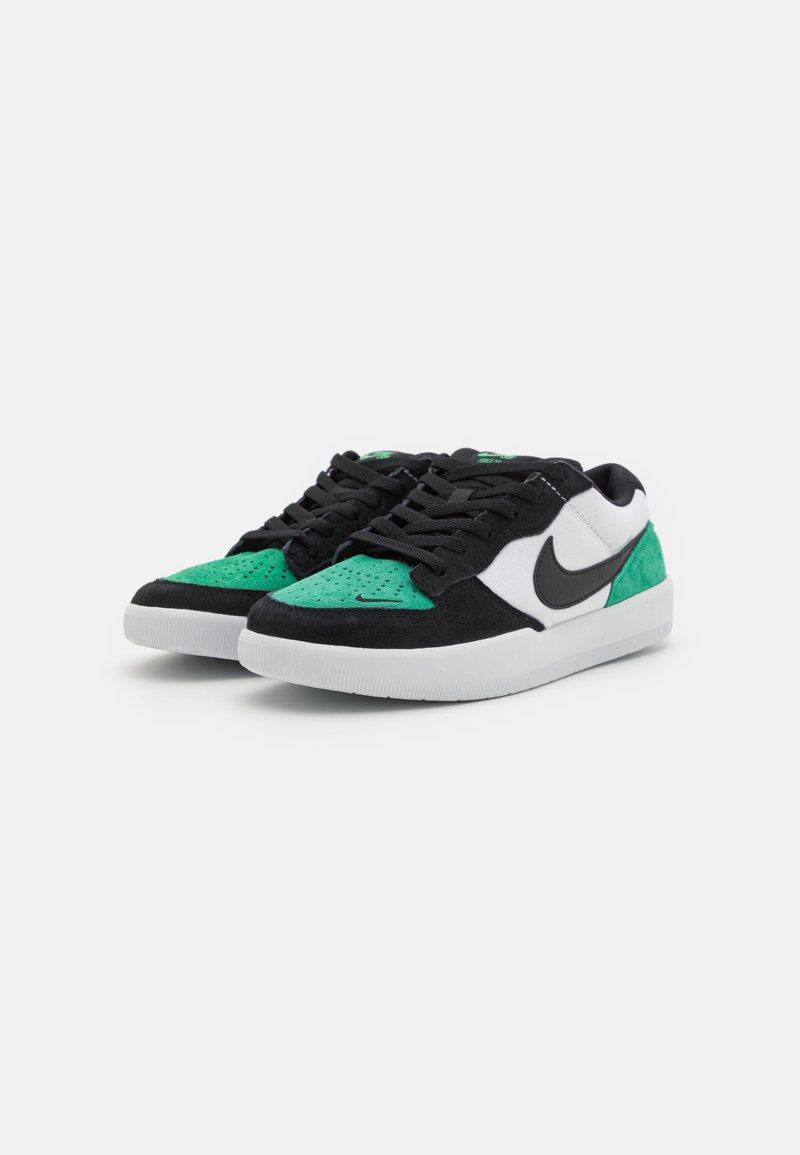 Des baskets en suede noir et vert possèdent un swoosh en cuir blanc, des textures contrastées, une languette rembourrée et des semelles extérieures en caoutchouc blanc.