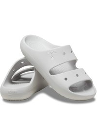 Zoccoli bianchi slip-on con punta e tallone aperti, realizzati in materiale foam leggero. Presentano fori di ventilazione e una soletta testurizzata.