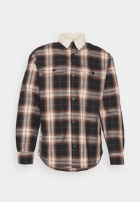 Geruit shirt in zwart, grijs en oranje. Kenmerkt zich door een witte fleece kraag, twee borstzakken en knoopsluiting. Gestructureerde geweven stof.
