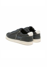 Baskets en cuir noir avec un dos texturé, des accents blancs et une fermeture éclair sur le côté. Présentent une doublure bleue et un logo sur le côté.