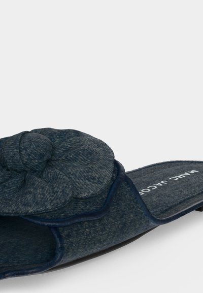 Blå stoff glidesandal med en stor stoffsløyfe på toppen og Marc Jacobs-merke på innersålen.