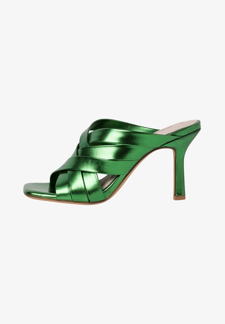 Mule à talons hauts vert brillant avec des brides en cuir croisées et un bout ouvert, dotée d'un talon fin et effilé et d'une semelle intérieure beige.