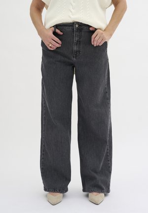 High-waisted, wide-leg jeans in dark gray denim, featuring a classic button closure and front pockets, paired with a knitted cream top.