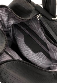 Black perforated handbag with multiple compartments, featuring a gray lined interior with repetitive text pattern and zip closure for organization.