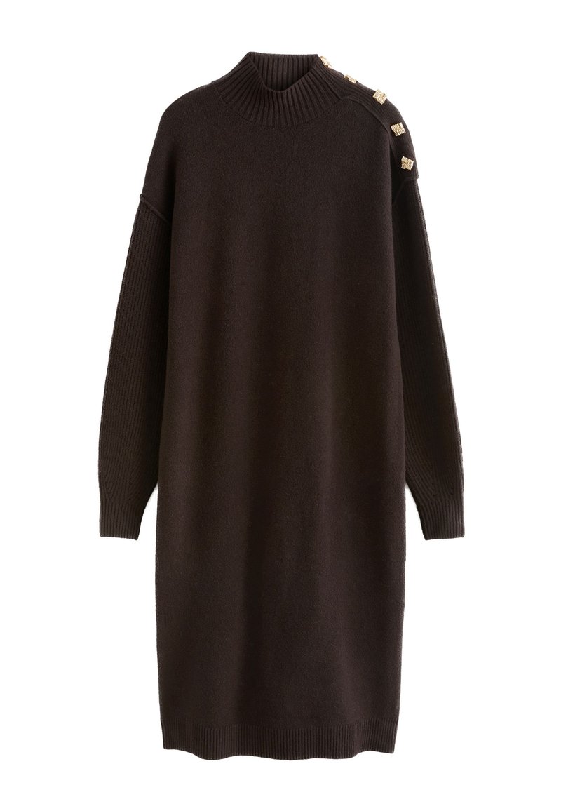 Mørkebrun strikket kjole med høj hals, lange ærmer og ribbet tekstur. Har dekorative guldknapper på skulderen som detalje.