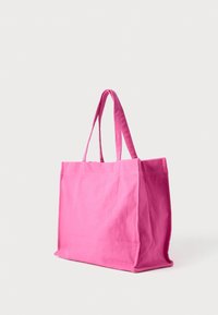 Ροζ τσάντα ώμου από καμβά με δύο ανθεκτικές λαβές, ορθογώνιο σχήμα και χωρίς ορατά σχέδια ή διακοσμήσεις. Λείο υλικό.