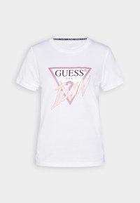 Hvid kortærmet t-shirt med et lyserødt trekantslogo og ordene "GUESS U.S.A" og "ICON" trykt på forsiden.