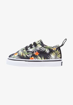 Baskets Vans noires avec imprimé de feuilles tropicales et fleurs orange, lacets noirs, semelle blanche et languette de maintien au talon, vue de côté.