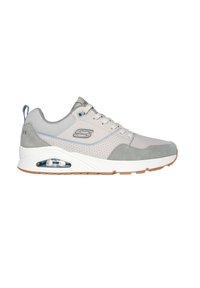 Zapatilla deportiva gris claro con materiales de ante y malla, acentos azules, cuello acolchado y tecnología de aire visible en la suela. Suela de goma.