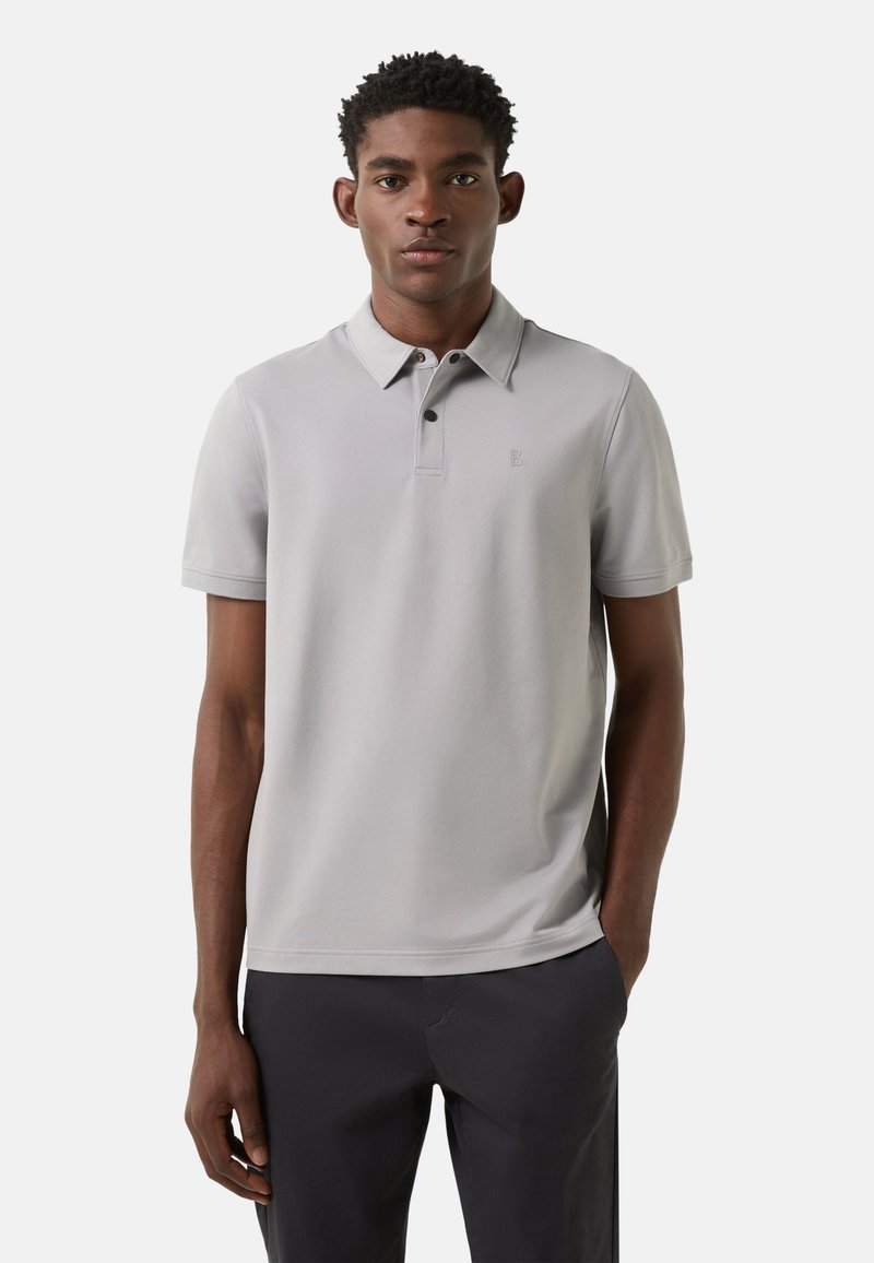 Light gray short-sleeve polo shirt with a classic collar, button placket, and subtle logo detail, made from smooth, breathable fabric.