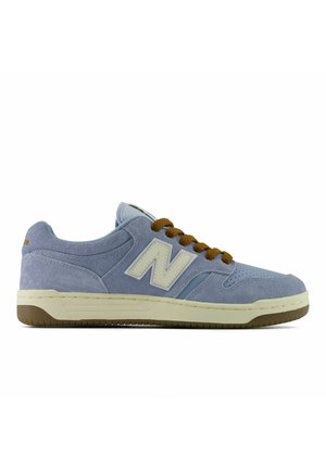 Baskets New Balance en daim bleu clair avec lacets marron, semelle beige et logo blanc sur le côté, vues de profil.