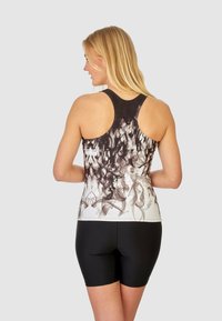 Zwart-wit racerback tanktop met een rookpatroon, gecombineerd met zwarte shorts. Zachte stof met een aansluitende pasvorm.