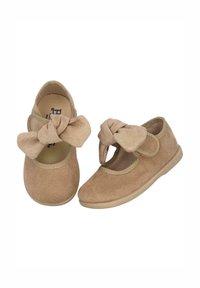 Zapatos de ante beige con punta redonda, estilo Mary Jane, con un gran lazo anudado en la parte delantera y una suela de goma flexible.