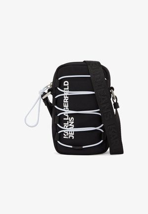 Black crossbody bag with white elastic cords, silver hardware, and "KARL LAGERFELD JEANS" text in white on front, featuring a wide black strap.