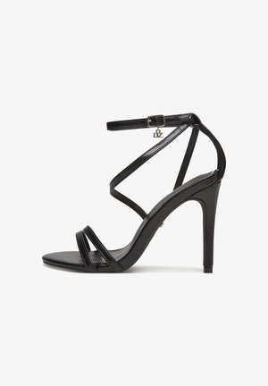Czarna sandałka na wysokim obcasie o błyszczącym wykończeniu, z cienkimi krzyżującymi się paskami, regulowanym paskiem wokół kostki oraz małym metalowym logo.