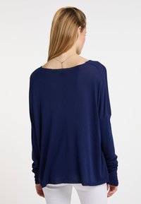 Maglione blu navy a maniche lunghe con ampia scollatura a barca e vestibilità rilassata. Presenta polsini sottili a coste e una texture morbida e leggera.