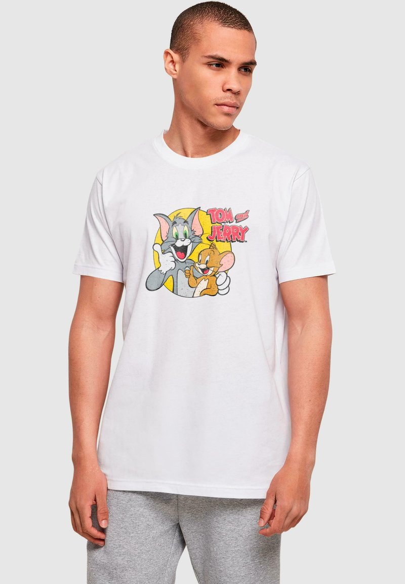 Camiseta de algodón blanca con un estampado colorido de los personajes de dibujos animados Tom y Jerry, con contornos negros gruesos y acentos amarillos.