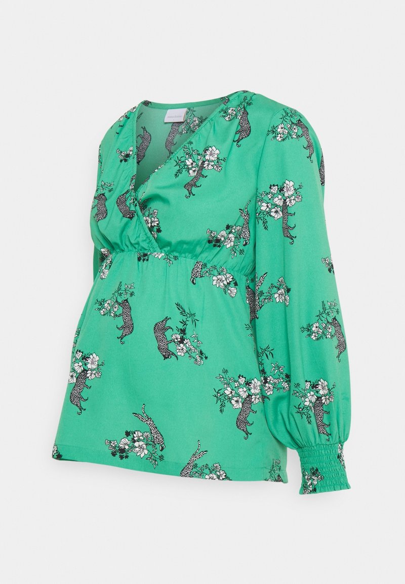 Blouse verte à manches longues avec taille et poignets froncés, ornée de motifs léopard et floraux en noir et blanc.