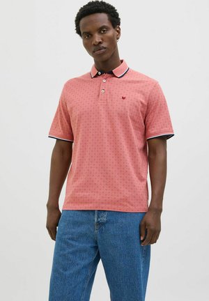 Polo shirt rose à manches courtes avec un petit motif circulaire, col contrastant en rose clair et bleu marine, et plastron à deux boutons.