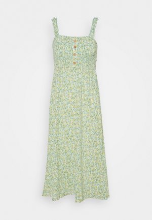 Vestido maxi floral en verde claro con flores amarillas y blancas. Presenta tirantes con volantes, un cuerpo fruncido y detalle de botones en el frente.